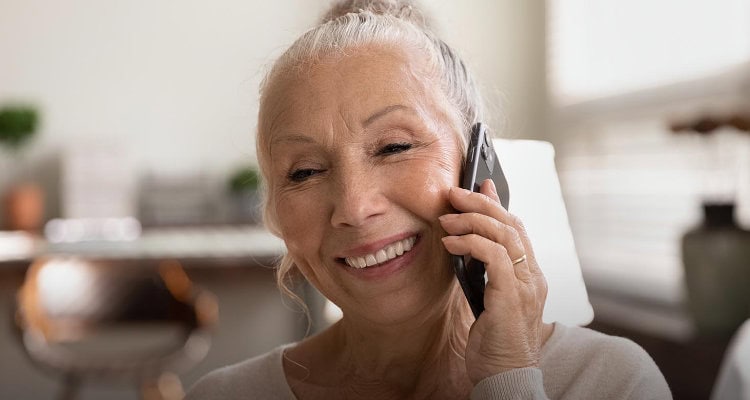 Happy,Elderly,Lady,Talking,On,Cellphone,,Making,Call,From,Home,