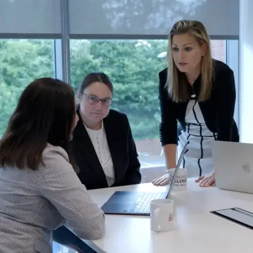 Three businesswomen in a meeting room.